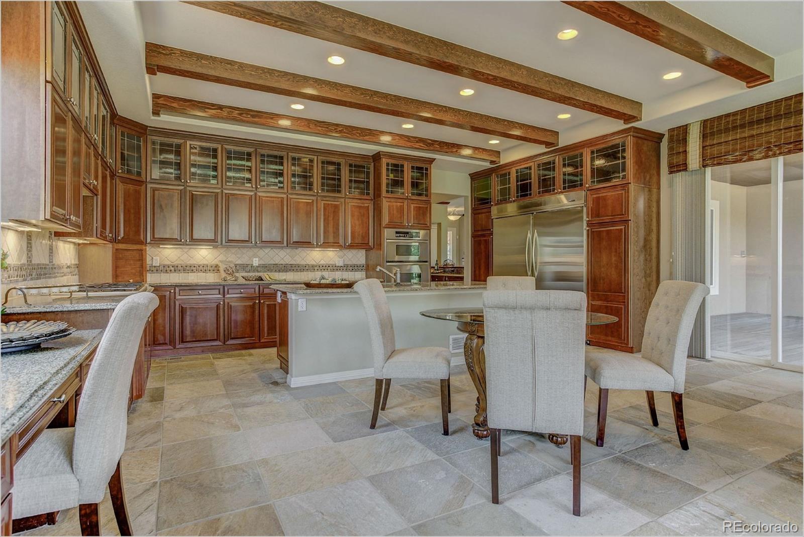 9061 Hunters Way Highlands Ranch, CO 80129 - Photo 8 of 33 a kitchen with stainless steel appliances granite countertop a sink and a refrigerator