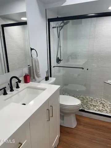 a bathroom with a sink a toilet and a shower
