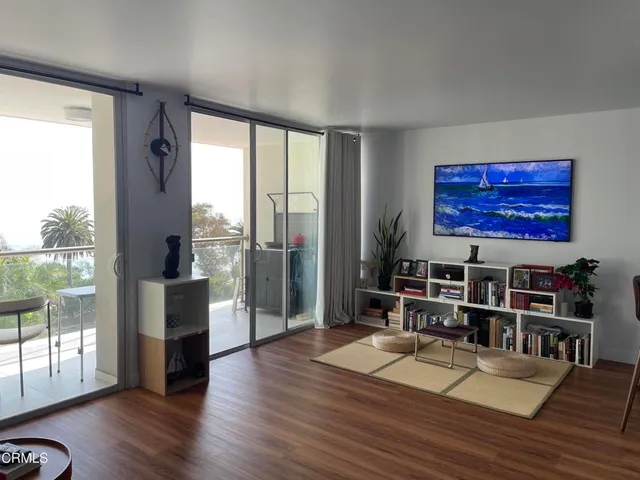 a living room with furniture wooden floor and a large window