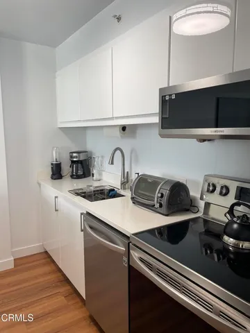 a kitchen with stainless steel appliances a sink a stove and cabinets