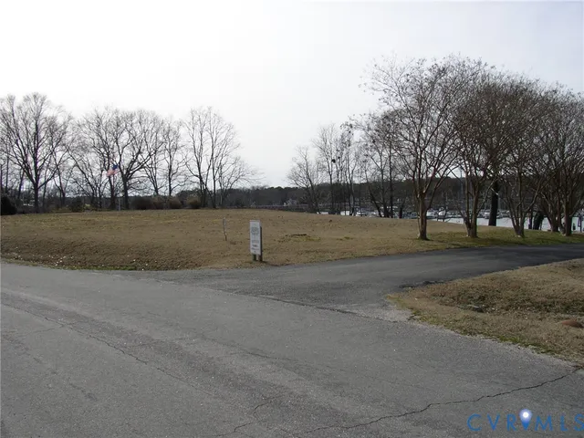 a view of dirt field with trees in background