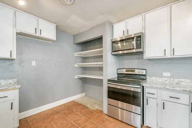 a kitchen with cabinets stainless steel appliances and wooden floor
