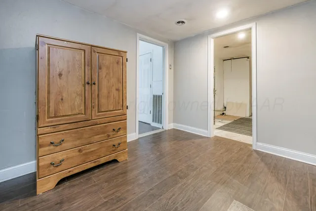 a view of a livingroom with wooden floor and staircase
