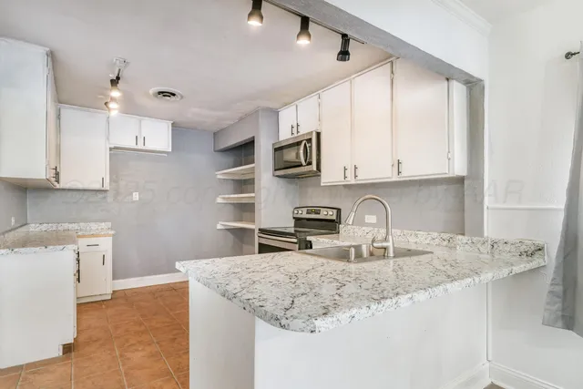 a kitchen with kitchen island granite countertop a sink window and cabinets