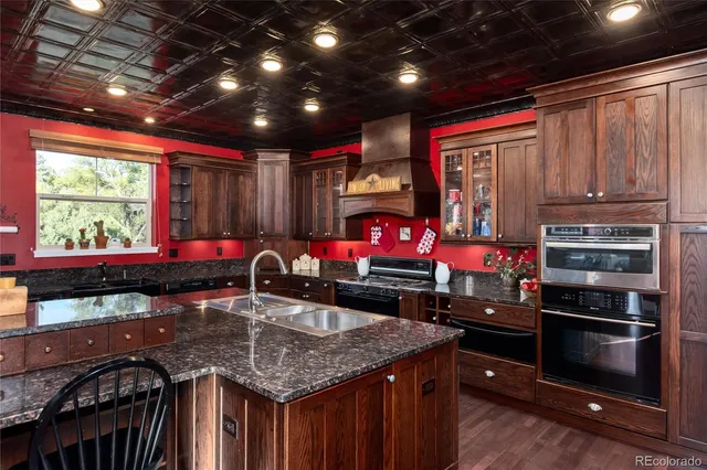 a kitchen with stainless steel appliances granite countertop a stove a sink and a microwave