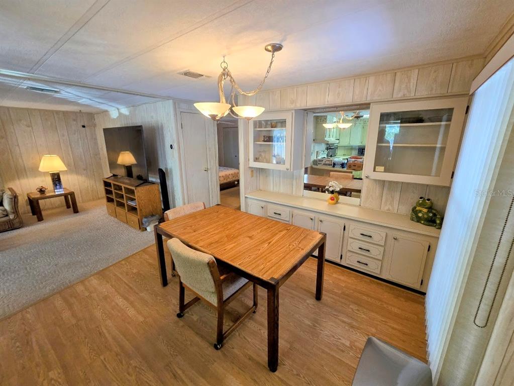 12501 Ulmerton Road, Unit 188 Largo, FL 33774 - Photo 19 of 63 a kitchen with a table chairs refrigerator and cabinets