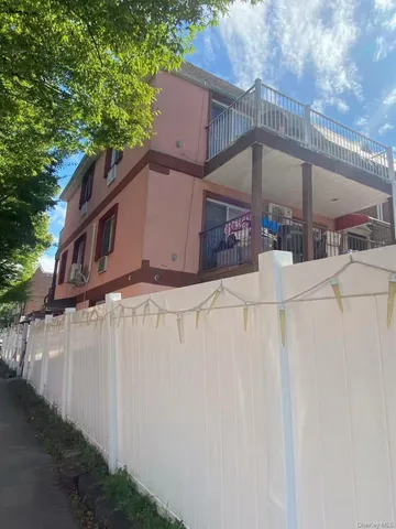 a view of a house with a wooden fence