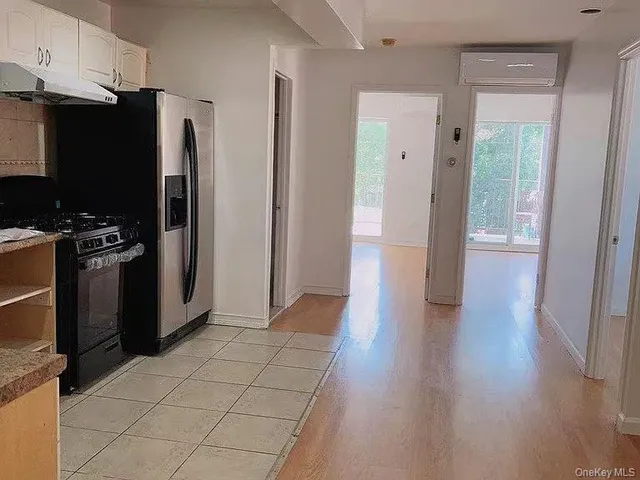 a view of a kitchen with refrigerator and car parked