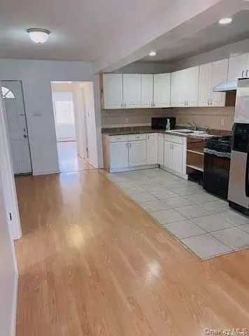 a large kitchen with granite countertop a stove top oven a sink and cabinets