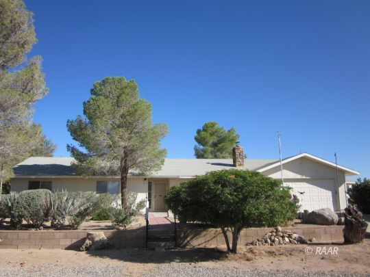 2127 West Ridgecrest Boulevard Ridgecrest, CA 93555 - Photo 1 of 30 a view of a house with a yard and table and chairs under an umbrella