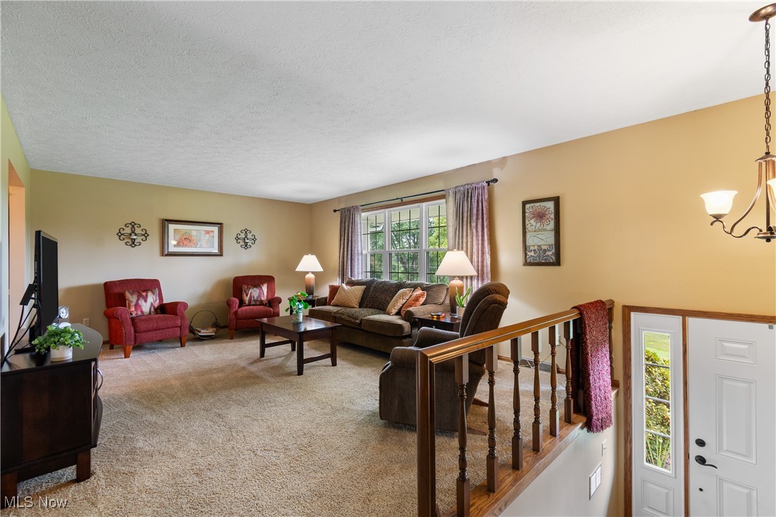 2560 Rutt Court Wooster, OH 44691 - Photo 4 of 33 Living area with a chandelier, carpet floors, and a textured ceiling