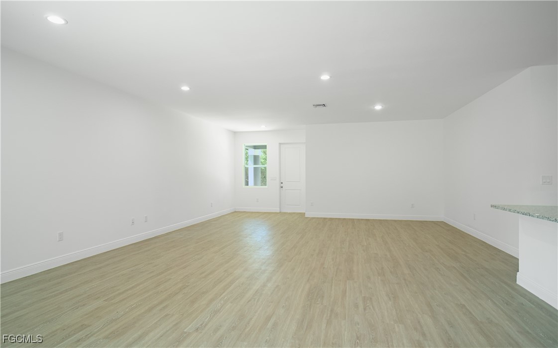 3059 Harvard Circle LaBelle, FL 33935 - Photo 4 of 10 an empty room with wooden floor and windows