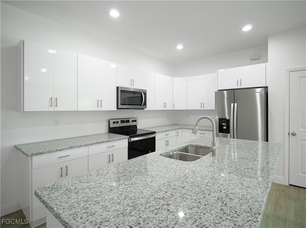 3059 Harvard Circle LaBelle, FL 33935 - Photo 7 of 10 a kitchen with granite countertop a refrigerator stove and sink