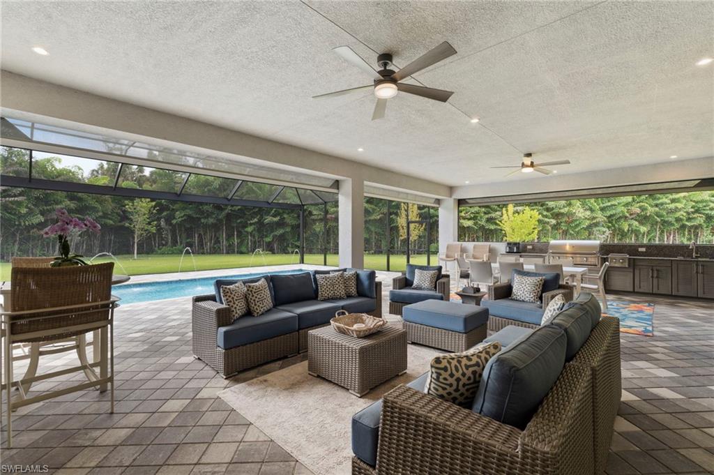 12083 Azalea Way Naples, FL 34120 - Photo 12 of 48 Experience optimal outdoor living with a 37' x 22' covered lanai area, with premium built-in outdoor kitchen, and feature wall, all protected from rain or storms with electric storm screens.