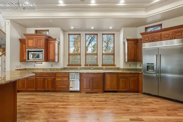 a large kitchen with granite countertop a sink and a refrigerator