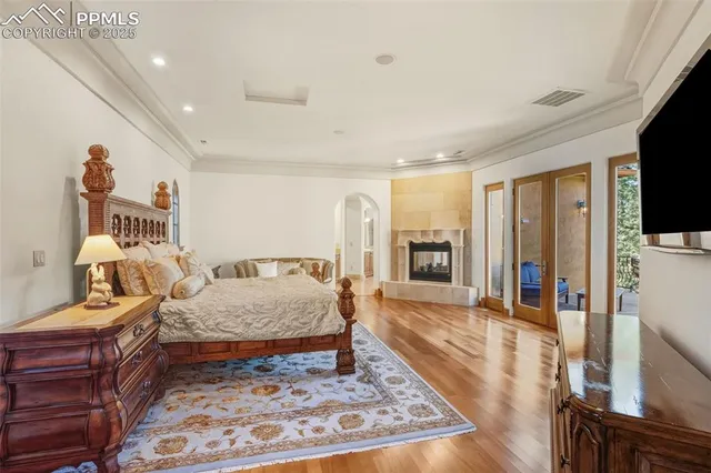 a large bedroom with a bed and wooden floor