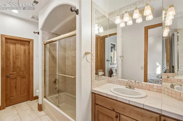 a bathroom with a shower sink and mirror