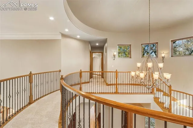 a view of a hallway with wooden floor and windows