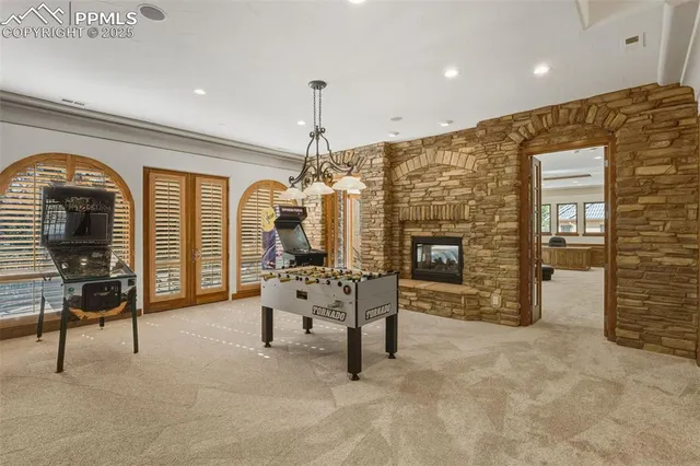 a living room with furniture a fireplace and a chandelier