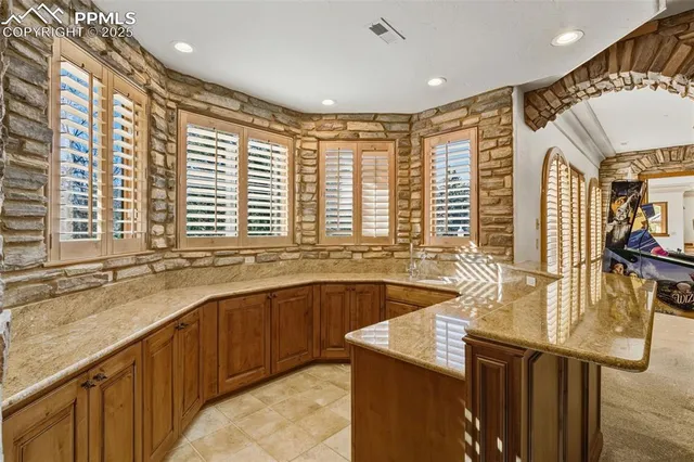 a large kitchen with stainless steel appliances granite countertop a sink and a counter space