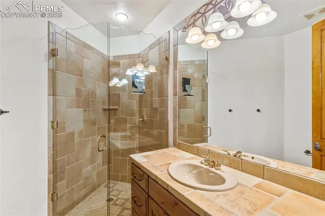a bathroom with a sink shower granite and a mirror