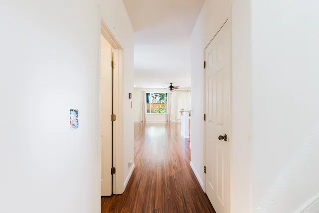 a view of a hallway with wooden floor