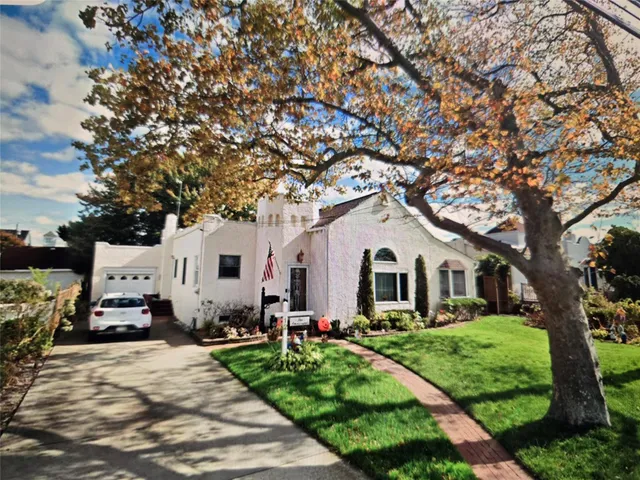a front view of a house with a yard and trees