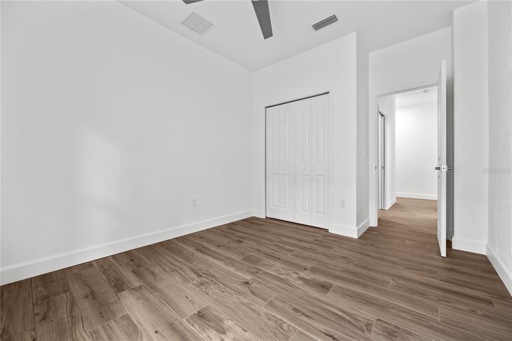 1086 Southwest 67th Drive Gainesville, FL 32607 - Photo 31 of 37 a view of an empty room with wooden floor and a bathroom