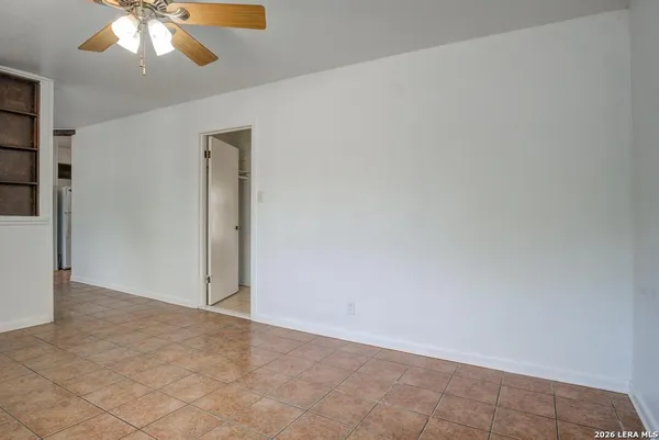 an empty room with a chandelier fan