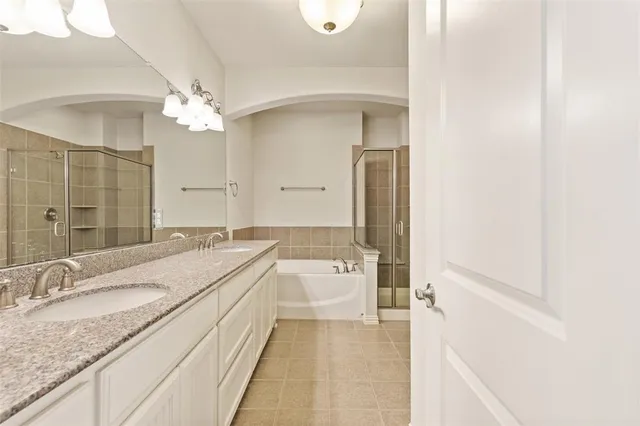 a spacious bathroom with a granite countertop sink a toilet a mirror and shower