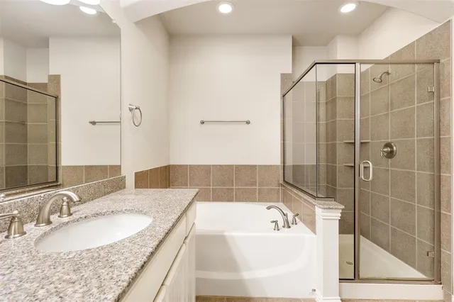 a bathroom with a granite countertop sink a mirror and shower