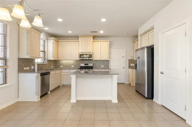 a kitchen with a refrigerator a sink and cabinets