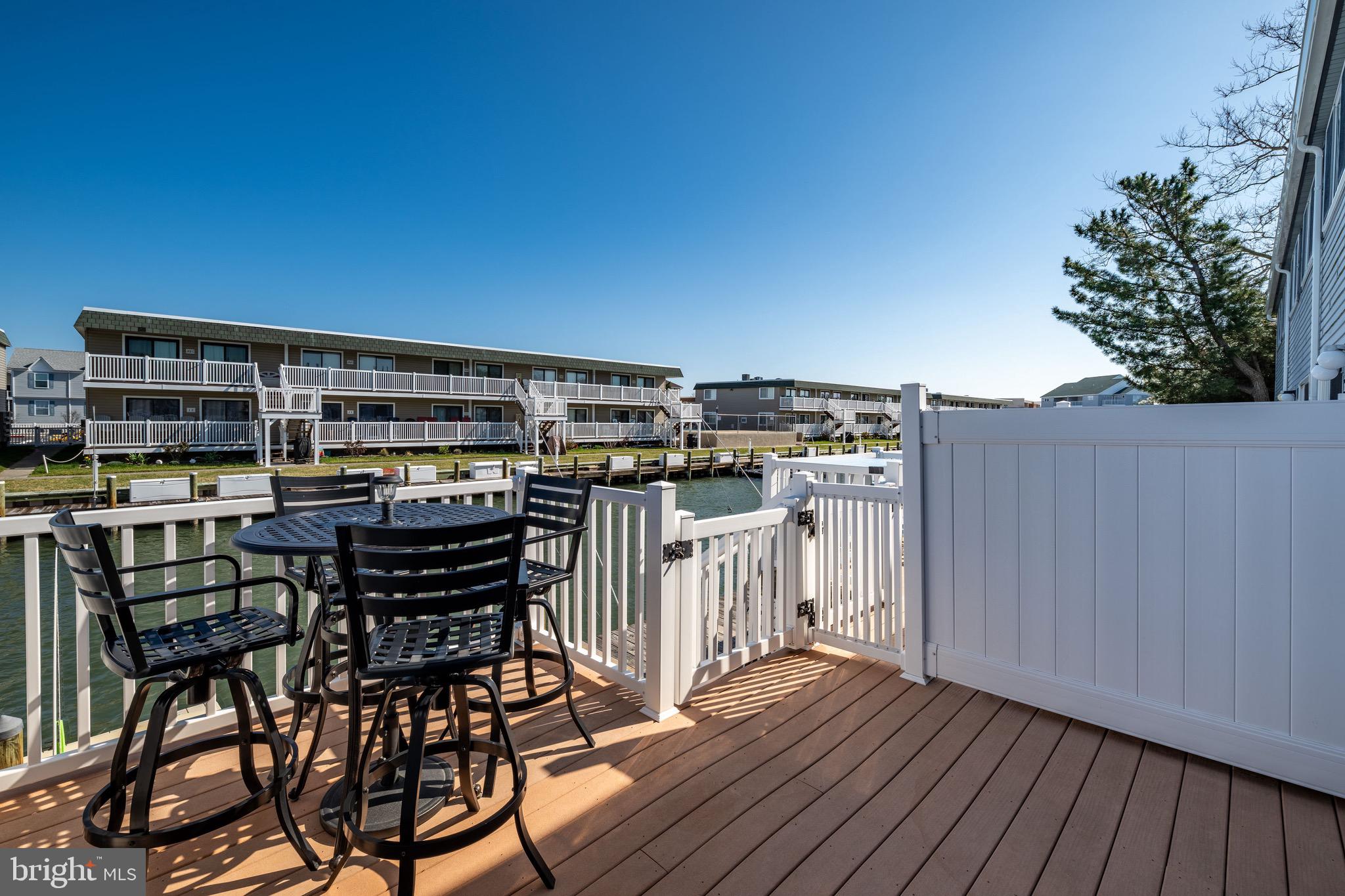720 Rusty Anchor Road, Unit 41C Ocean City, MD 21842 - Photo 12 of 32 a view of a chairs and table on the wooden roof deck