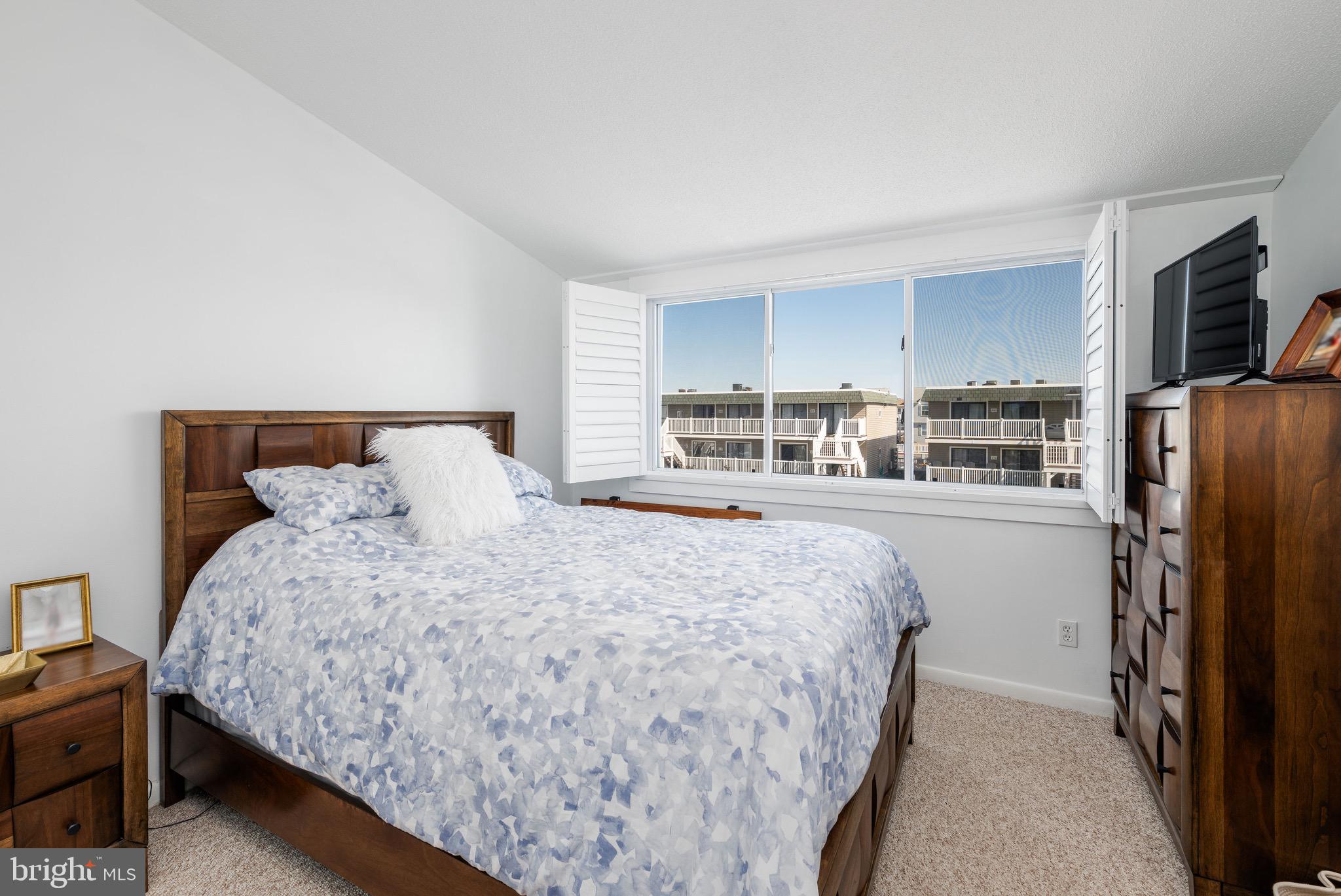 720 Rusty Anchor Road, Unit 41C Ocean City, MD 21842 - Photo 18 of 32 a bedroom with bed and flat tv screen on the dresser
