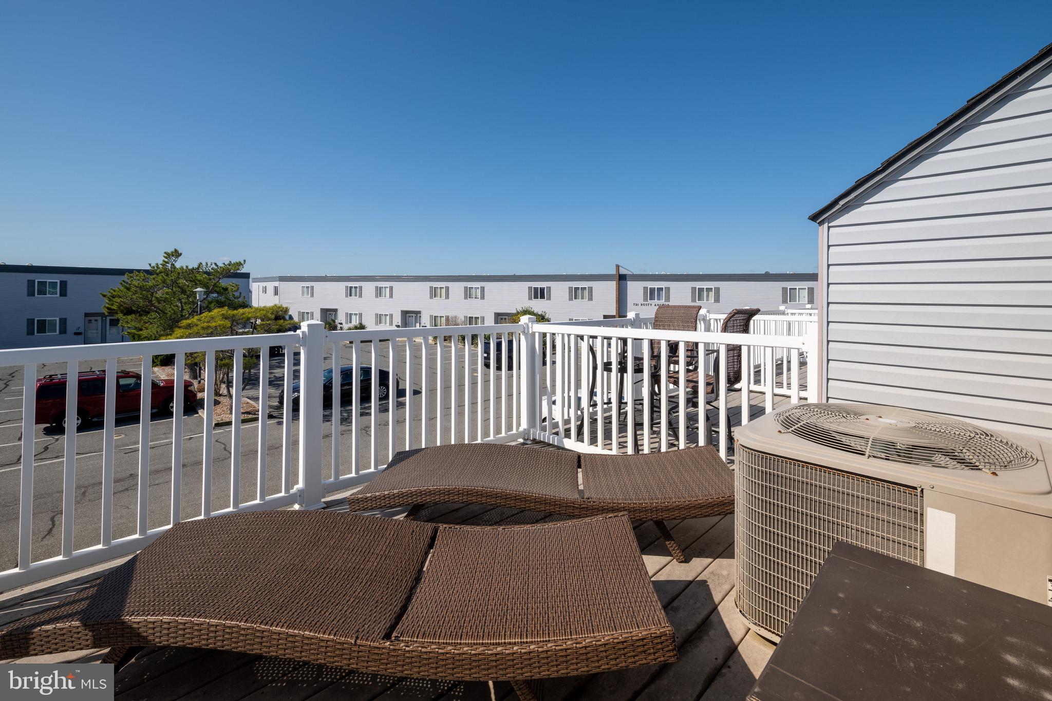 720 Rusty Anchor Road, Unit 41C Ocean City, MD 21842 - Photo 23 of 32 a view of a balcony with a table and chairs