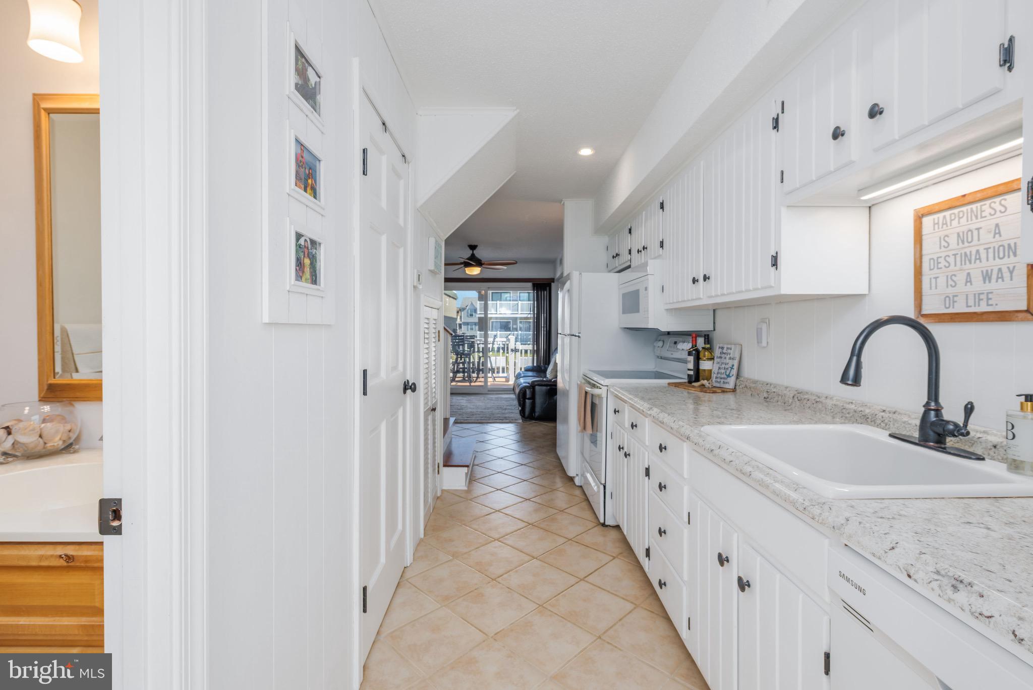 720 Rusty Anchor Road, Unit 41C Ocean City, MD 21842 - Photo 5 of 32 a large white kitchen with granite countertop a sink and cabinets