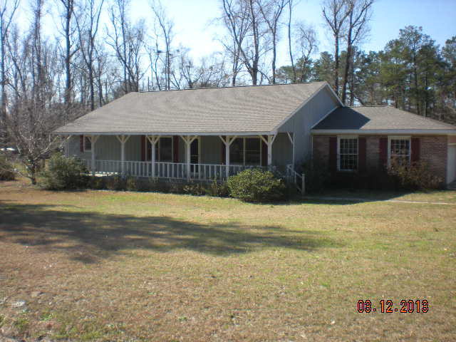 a front view of house with yard and trees around