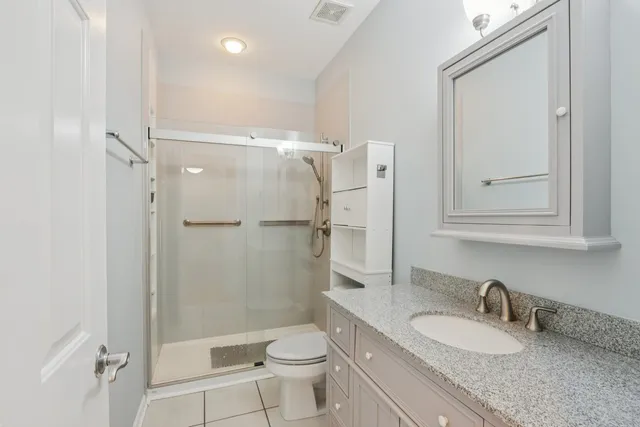 a bathroom with a granite countertop sink toilet and shower