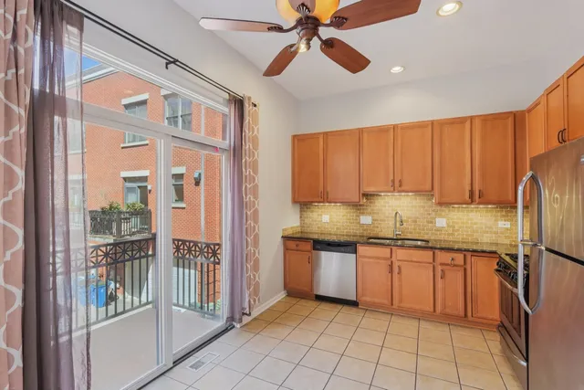 a kitchen with stainless steel appliances granite countertop a refrigerator a sink and dishwasher