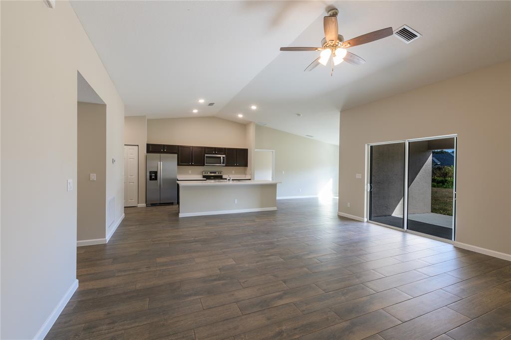 730 Southwest McCall Road Port St. Lucie, FL 34953 - Photo 3 of 28 a view of kitchen with cabinets and wooden floor