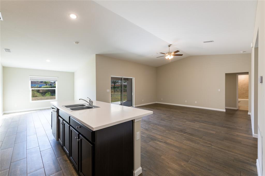 730 Southwest McCall Road Port St. Lucie, FL 34953 - Photo 4 of 28 a open kitchen with a sink and dishwasher with wooden floor