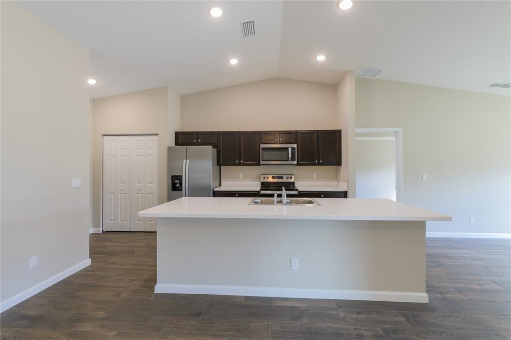 730 Southwest McCall Road Port St. Lucie, FL 34953 - Photo 7 of 28 a view of kitchen with stainless steel appliances wooden floor and window