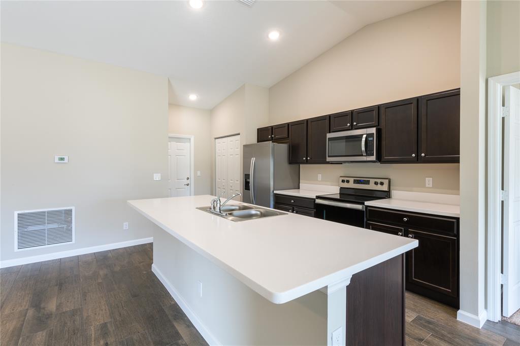 730 Southwest McCall Road Port St. Lucie, FL 34953 - Photo 8 of 28 a kitchen that has a sink a stove top oven a counter space and cabinets