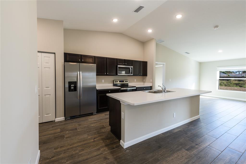 730 Southwest McCall Road Port St. Lucie, FL 34953 - Photo 9 of 28 a kitchen with stainless steel appliances a refrigerator and a stove top oven