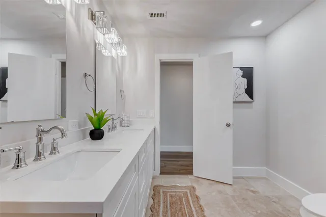 a bathroom with a granite countertop sink a toilet and shower