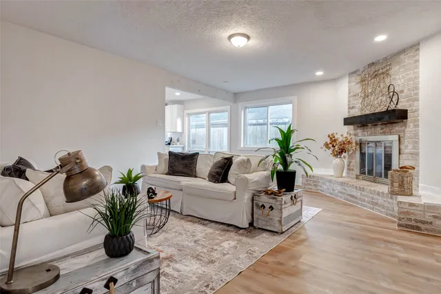 a living room with furniture a fireplace and wooden floor