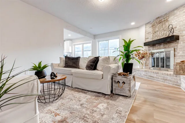 a living room with furniture a chandelier and a potted plant