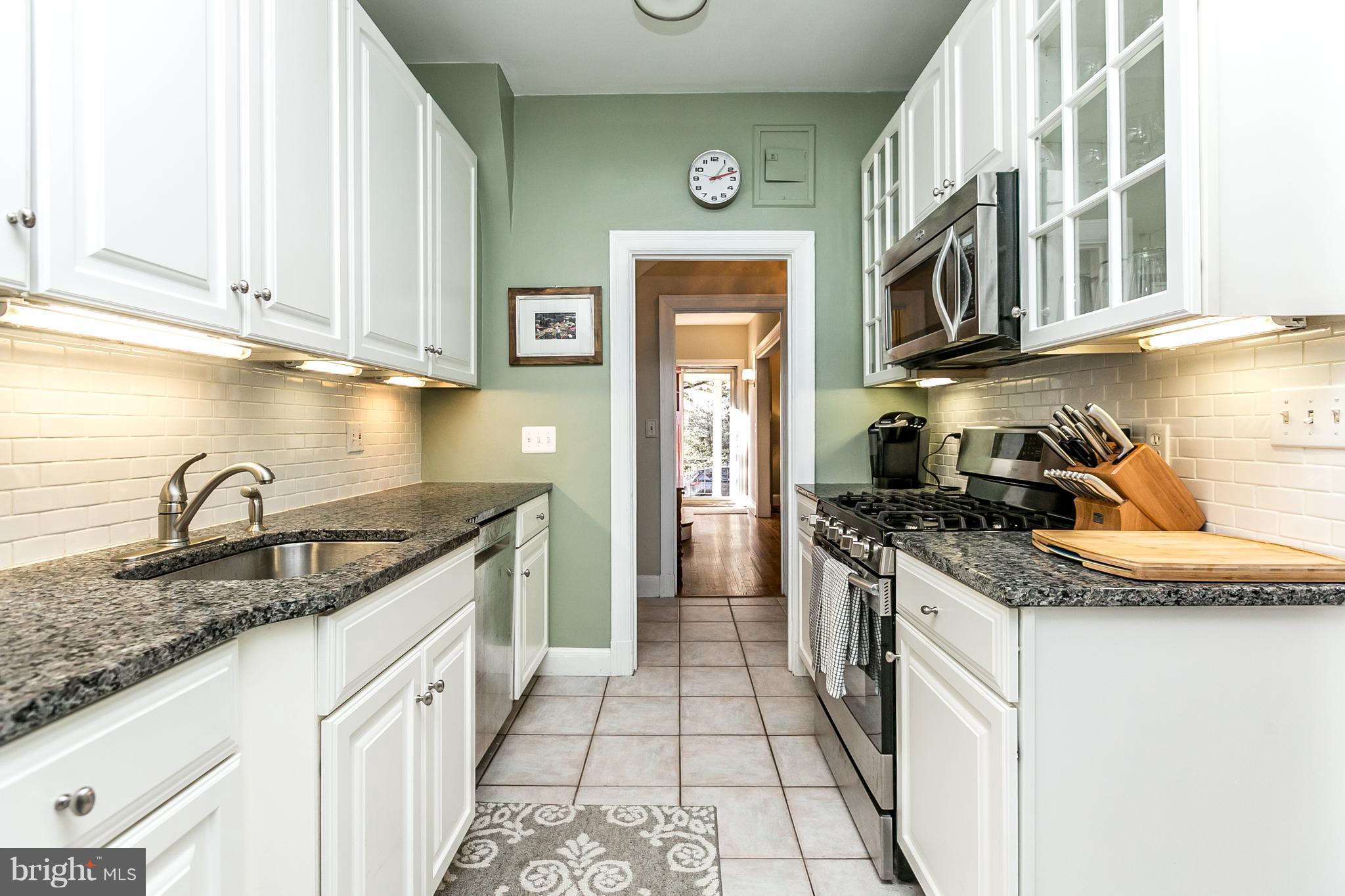 4223 Wickford Road Baltimore, MD 21210 - Photo 9 of 36 a kitchen with granite countertop a sink stove and cabinets