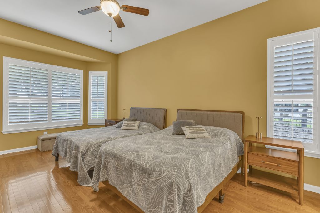 144 Cattle Trail Way Georgetown, TX 78633 - Photo 15 of 37 Hardwood flooring extends through this bright bedroom, offering multiple windows with plantation shutters.