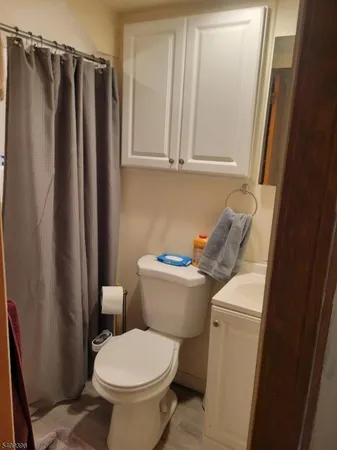 a bathroom with a toilet and a shower curtain